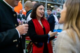 A woman with a red scarf talking to someone else