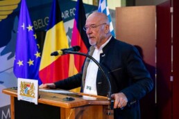 Wolfram Hatz giving a speech with the European and German flags in the background