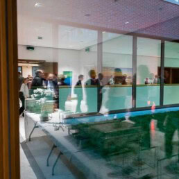 A room full of people networking viewed from the reflection of a window
