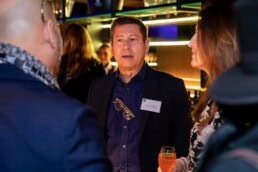 A man having a conversation with two other people during the NYC Tourism Convention in Brussels