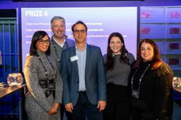 A group of five people posing for the camera after the person in the middle received a prize during the NYC Tourism Convention in Brussels