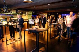 A group of people listening to a speaker in a room during the NYC Tourism Convention in Brussels