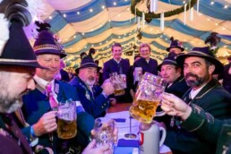 A group of man dressed in typical Bavarian outfits celebrating with beer during the Brussels Oktoberfest 2025