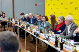 A group of people sitting at a conference table, including Peter Hauk
