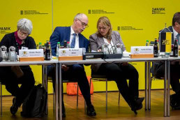 Two people speaking at a conference table during a conference in Brussels 2025