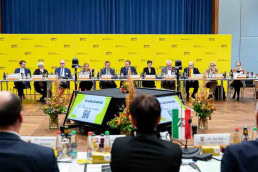 A group of people sitting at a conference table, including Peter Hauk