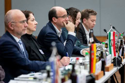 A group of people sitting at a conference table listening carefully another non visible speaker at a conference in Brussels 2025