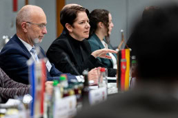 A woman with short dark hair speaking at a conference in Brussels 2025