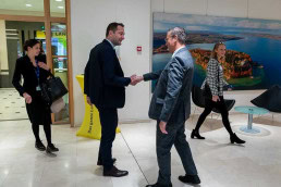 Christophe Hansen shaking hands with Peter Hauk at a conference in Brussels 2025