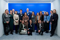 A group of a attendees pose for a photo in front of a blue banner during the 2025 Epilepsy and Rare Diseases Conference at the European Parliament in Brussels