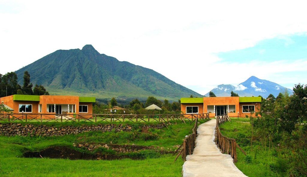 A path leading to orange chalets with a mountain in the background