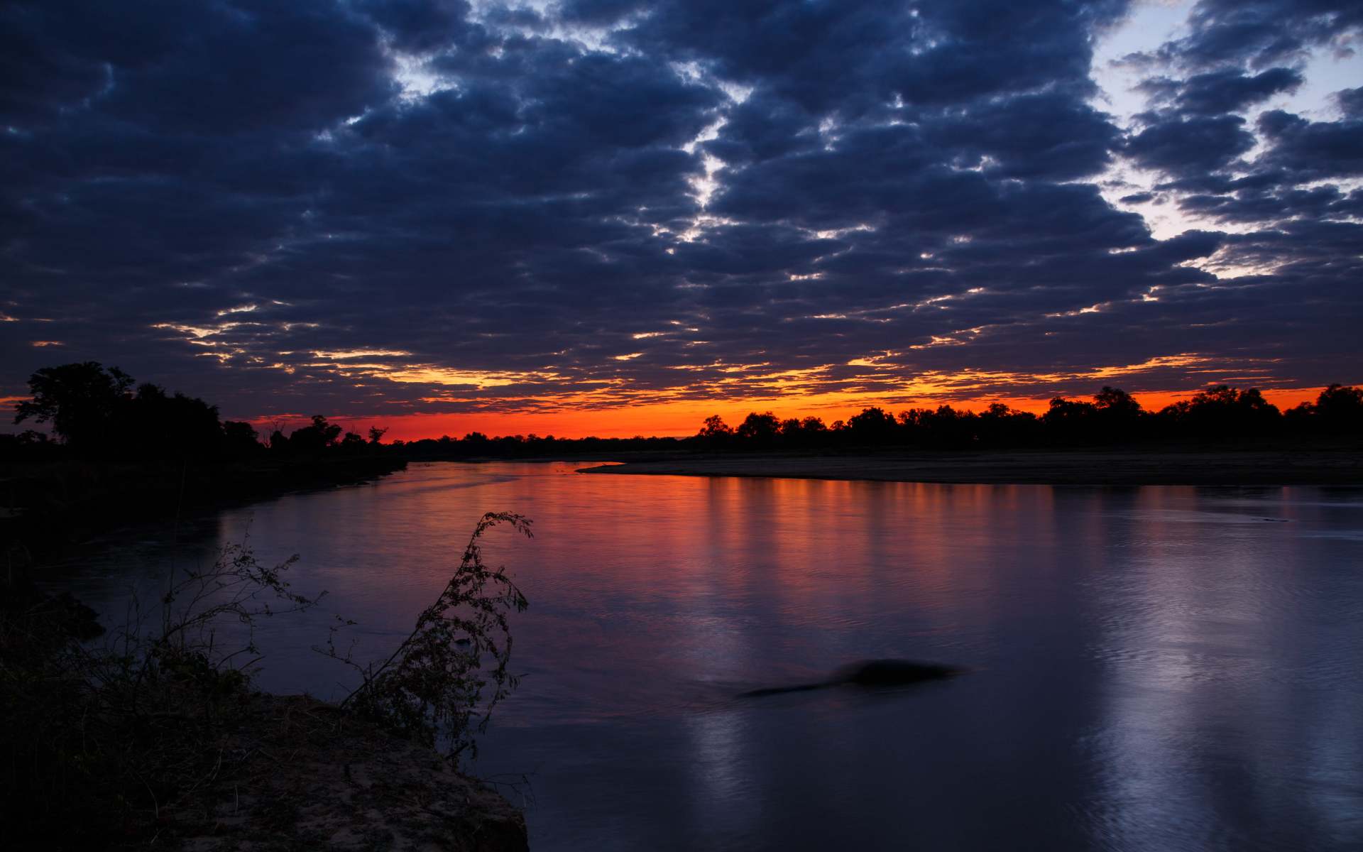 View of sunset over body of water in Zambia