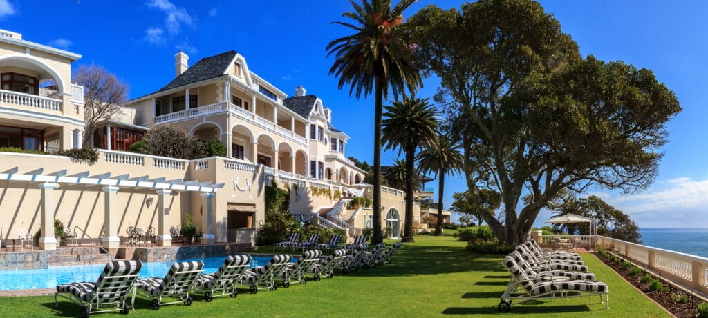 View of Ellerman House with green grass a palmtrees in Cape Town, and ideal location for a South Africa honeymoon