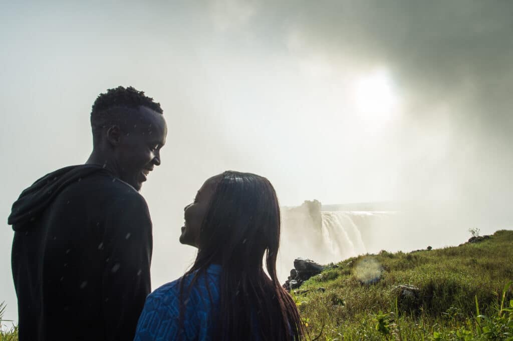 A happy couple on honeymoon standing in the Victoria Falls mist