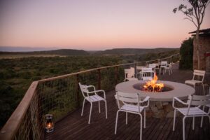 Chairs around a small fire with the sunset in the background