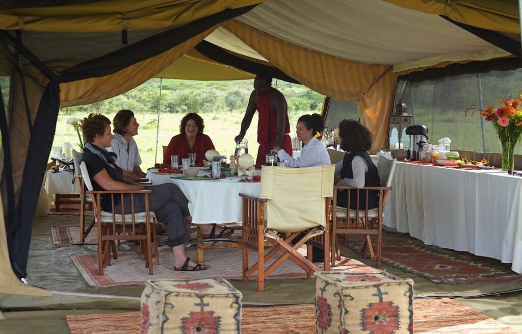 People sitting around a table in their mobile camp