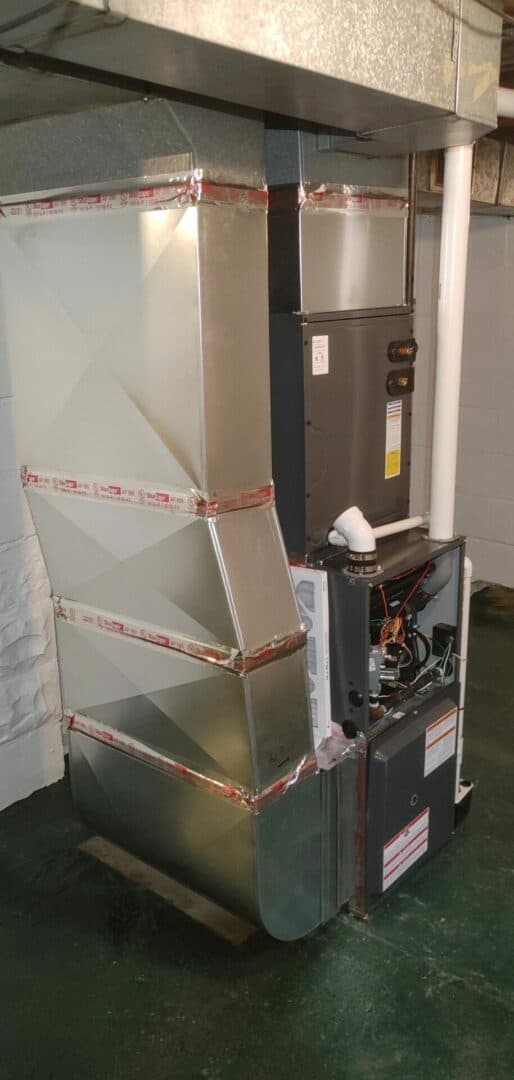 HVAC furnace unit with ductwork and control panel in basement.