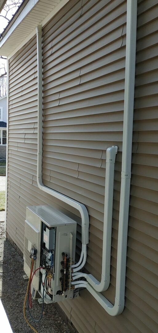 External HVAC unit with electrical wiring and conduit on beige siding.
