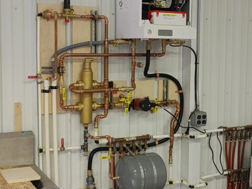 HVAC boiler system with copper piping and control unit mounted on wall.