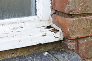 Rotted and deteriorating wooden residential window frame