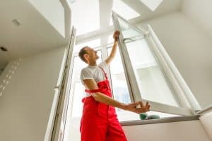 Contractor installing a replacement window in a home