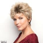 Stylish short blonde wig on a woman with a red top and hoop earrings.