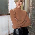 Stylish short blonde wig on a woman with a modern look in an industrial setting.