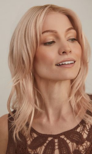 Blonde wavy bob wig worn by a woman with light makeup and a lace top.
