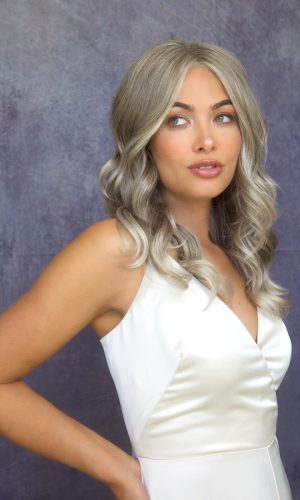 Woman with long, silver wavy wig and natural makeup.