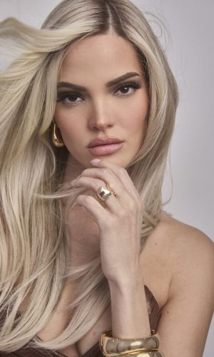 Beautiful blonde woman with long wavy hair and elegant jewelry.