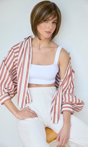 Woman wearing a short bob wig with layered brown hair and side-swept bangs.