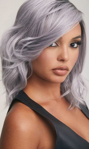 Woman with silver gray wavy wig and natural makeup.