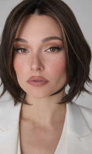 Woman with a short, layered bob wig in dark brown with subtle highlights.