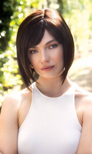 Woman with short, straight brown bob wig outdoors in sunlight.
