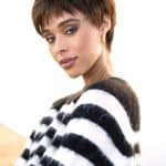Woman wearing a short brown wig with layered styling and side-swept bangs.