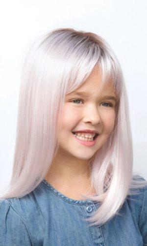 Young girl with long, straight, platinum blonde wig smiling.