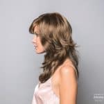 Side view of a woman with long, layered, light brown wig from Hidden Secrets Wigs.