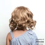 Blonde curly wig from Hidden Secrets Wigs, styled for a natural look.