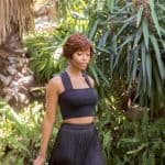 Elegant woman with short wig in lush garden setting for Hidden Secrets Wigs.