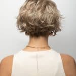 Curly short wig in ash blonde with layered texture for a natural look.