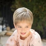 Child with short blonde wig from Hidden Secrets Wigs.
