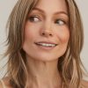 Elegant woman wearing a long, wavy blonde wig from Hidden Secrets Wigs.