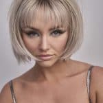 Blonde bob wig with bangs, styled for a modern look.