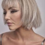 Blonde bob wig with layered cut and bangs, styled for a modern look.