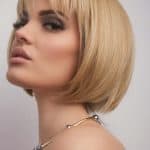 Blonde bob wig with side-swept bangs for a stylish look.