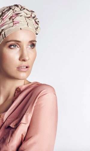 Elegant printed turban worn by a woman with a pink blouse.