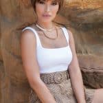 Short layered wig in ash brown with textured bangs on a woman.