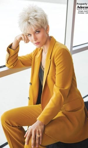 Model wearing a short, platinum blonde wig with textured layers.