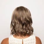 Wavy shoulder-length wig in light brown with subtle highlights.