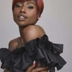Stylish woman with short red wig and black ruffled dress for elegant look.